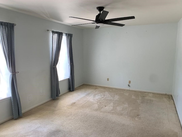 carpeted spare room featuring ceiling fan