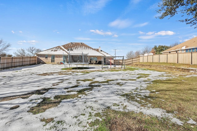 back of property featuring a trampoline