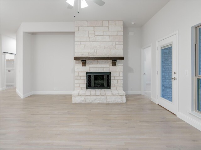 unfurnished living room with a fireplace, ceiling fan, and light hardwood / wood-style floors