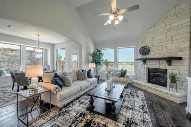 living room featuring dark wood-type flooring, a fireplace, high vaulted ceiling, and ceiling fan