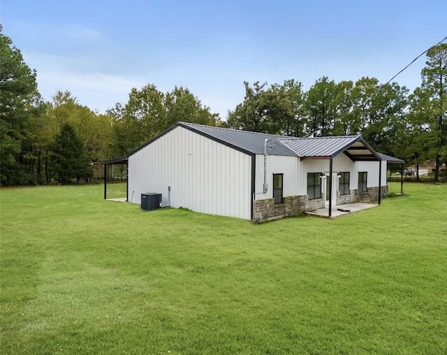 rear view of property featuring cooling unit and a yard