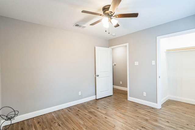 unfurnished bedroom with ceiling fan, light wood-type flooring, and a closet