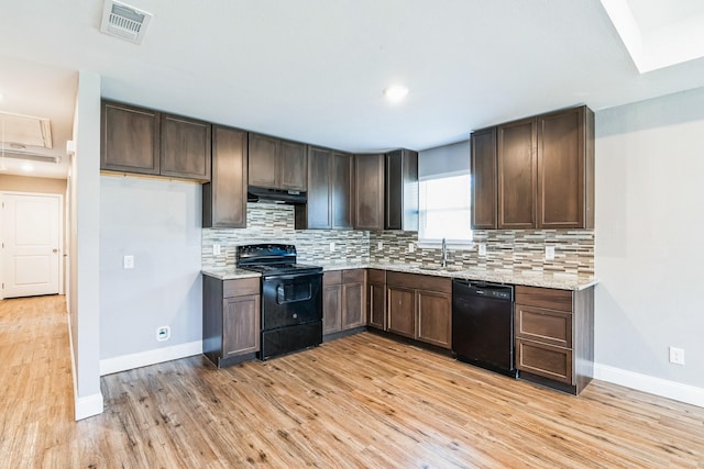 kitchen featuring black appliances, sink, decorative backsplash, light wood-type flooring, and light stone countertops