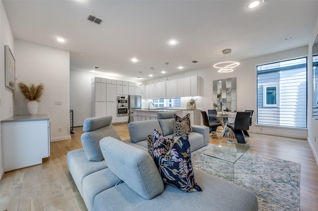 living room with light wood-type flooring and sink