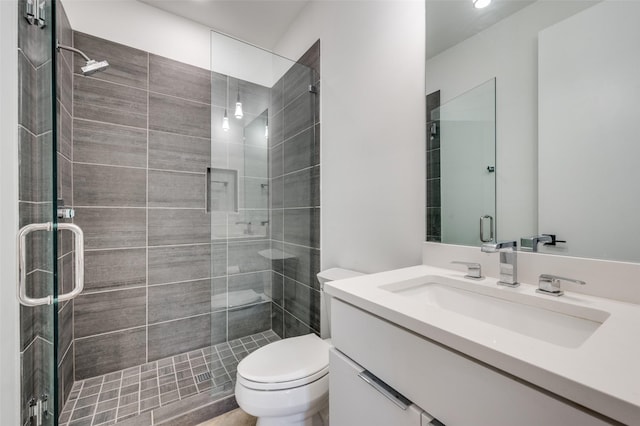 bathroom featuring vanity, toilet, and an enclosed shower