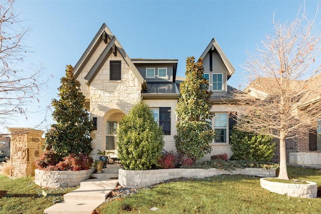 tudor home with a front lawn