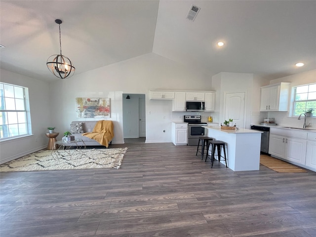 kitchen with sink, white cabinetry, a kitchen breakfast bar, stainless steel appliances, and a center island