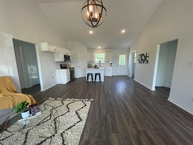 unfurnished living room with sink, dark wood-type flooring, high vaulted ceiling, and a chandelier