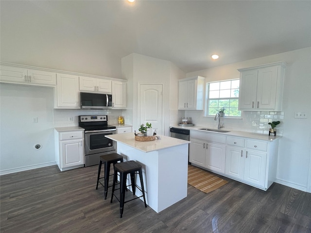 kitchen featuring stainless steel appliances, white cabinetry, and a center island