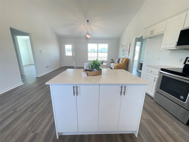 kitchen with stainless steel range with electric stovetop, hanging light fixtures, white cabinetry, a center island, and vaulted ceiling