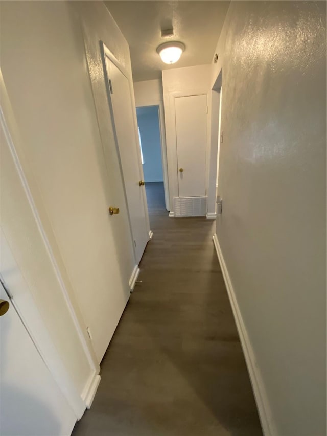 hallway with dark hardwood / wood-style flooring