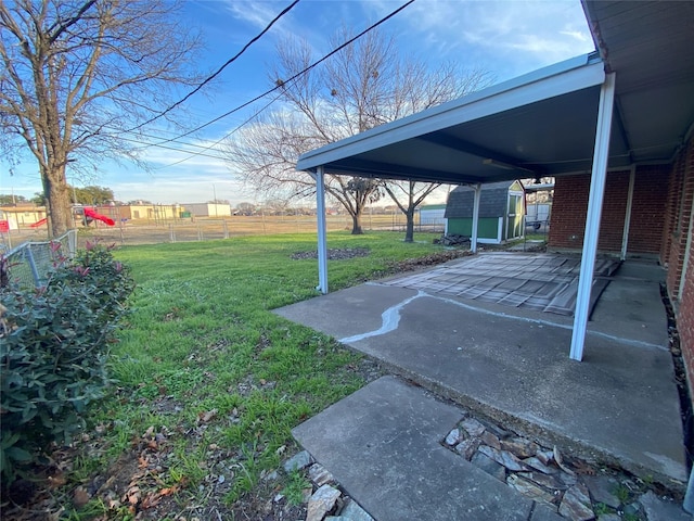 view of yard featuring a storage unit and a patio area