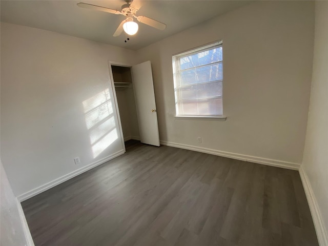 empty room featuring ceiling fan and dark wood-type flooring