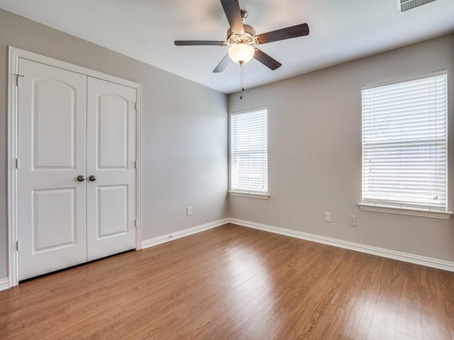 unfurnished bedroom with ceiling fan, a closet, and light hardwood / wood-style floors