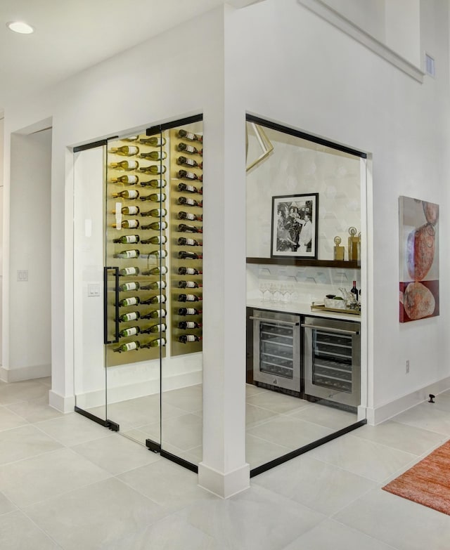 wine room with light tile patterned floors, wine cooler, and indoor bar