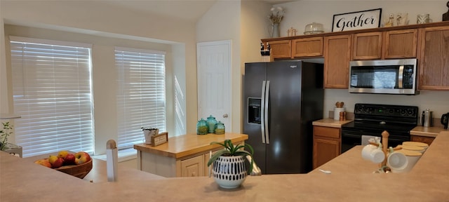 kitchen featuring vaulted ceiling, a healthy amount of sunlight, and black appliances