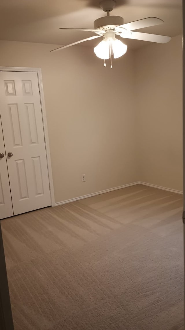 spare room featuring ceiling fan and carpet flooring