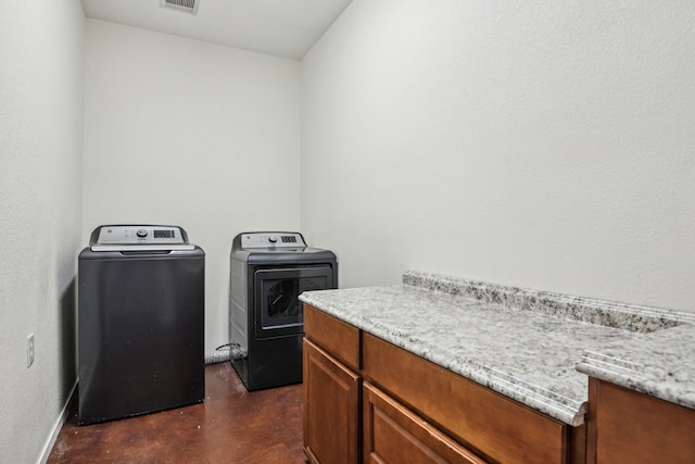 laundry area featuring washing machine and dryer and cabinets