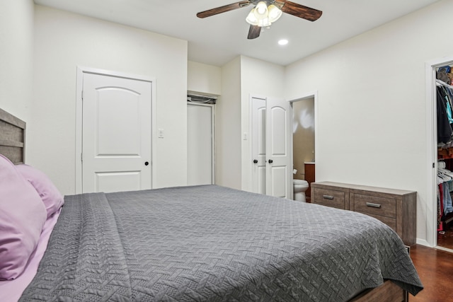 bedroom featuring ceiling fan, dark wood-type flooring, and ensuite bathroom