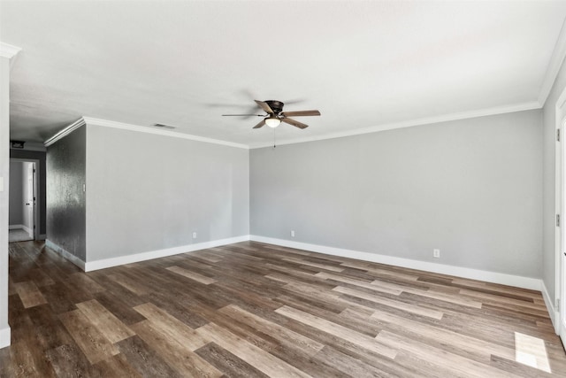 empty room with visible vents, ornamental molding, a ceiling fan, wood finished floors, and baseboards