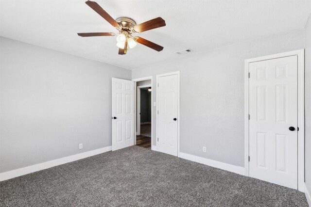 unfurnished bedroom featuring dark colored carpet and ceiling fan