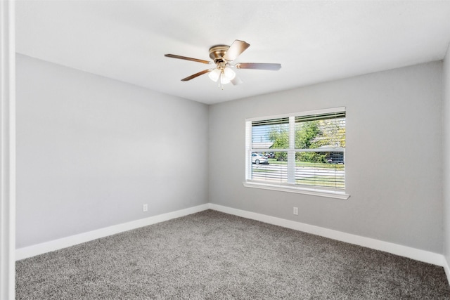 carpeted spare room featuring a ceiling fan and baseboards