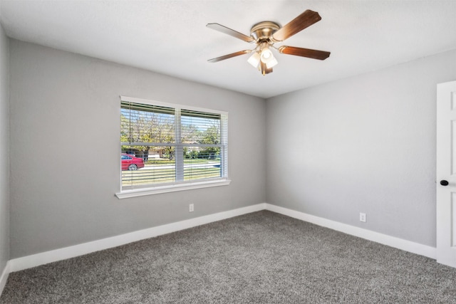 carpeted empty room with ceiling fan and baseboards