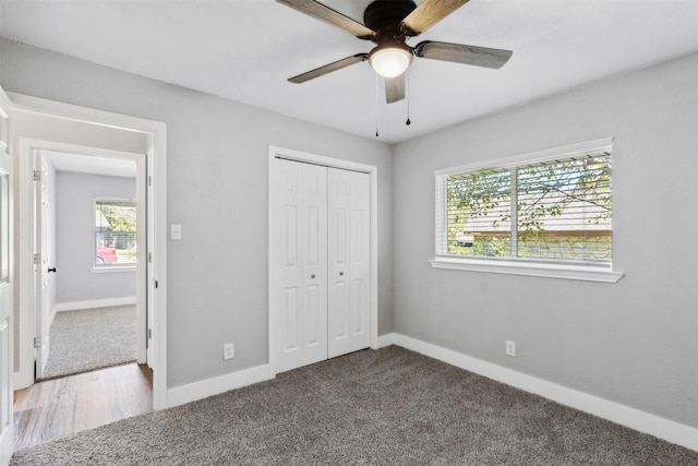 unfurnished bedroom featuring ceiling fan, a closet, carpet flooring, and baseboards