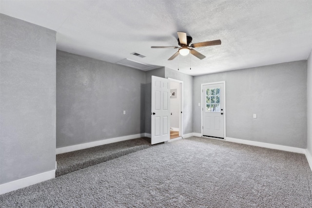 unfurnished room with dark colored carpet, ceiling fan, a textured ceiling, and baseboards