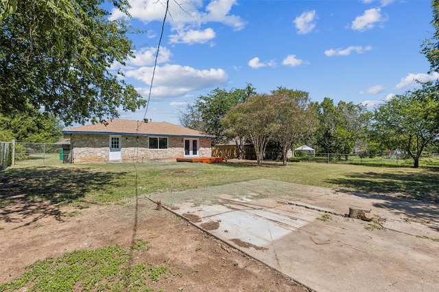 back of property with stone siding, a patio area, and a fenced backyard