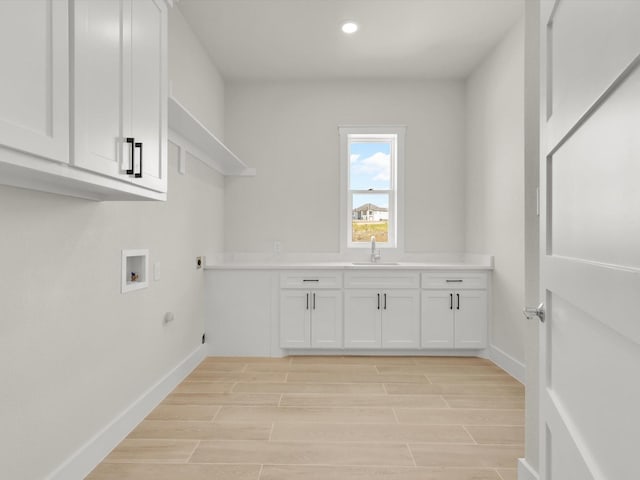 washroom featuring sink, cabinets, hookup for a gas dryer, washer hookup, and electric dryer hookup