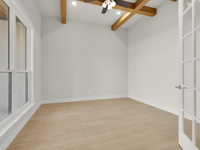 spare room with beam ceiling and light hardwood / wood-style flooring