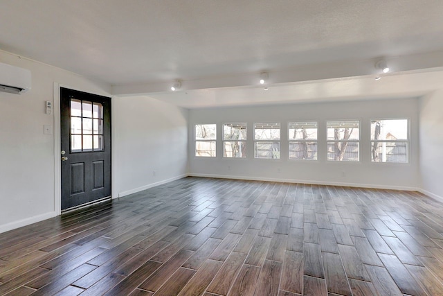 foyer featuring beam ceiling and a wall unit AC