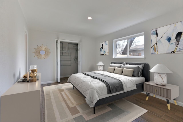 bedroom featuring dark wood-type flooring, a closet, and a walk in closet