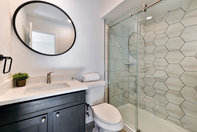 bathroom featuring toilet, an enclosed shower, and vanity