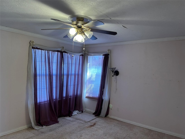 carpeted empty room featuring ceiling fan, crown molding, and a textured ceiling