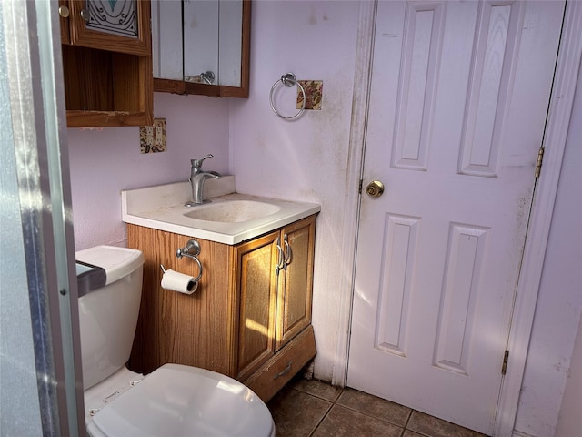 bathroom featuring vanity, tile patterned floors, and toilet