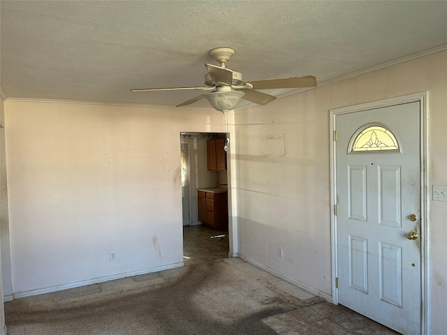 empty room with ceiling fan, light colored carpet, and a textured ceiling