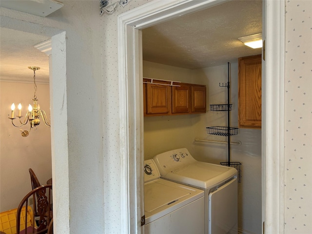 washroom featuring a chandelier, washer and clothes dryer, cabinets, and a textured ceiling