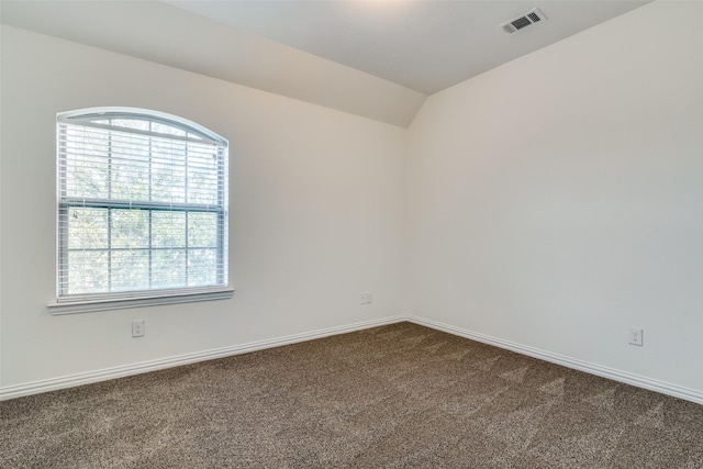 carpeted spare room featuring lofted ceiling