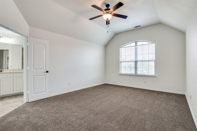 carpeted empty room with ceiling fan and vaulted ceiling