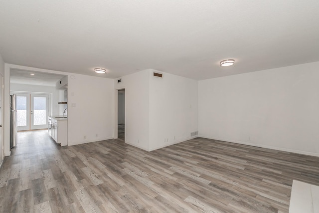 spare room featuring french doors, light wood-type flooring, and sink