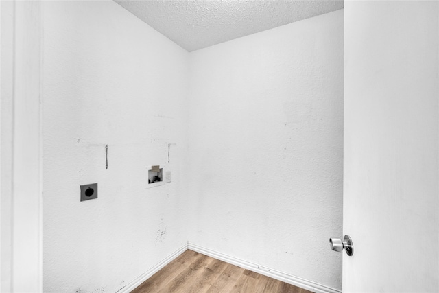 laundry area with electric dryer hookup, hookup for a washing machine, a textured ceiling, and hardwood / wood-style flooring