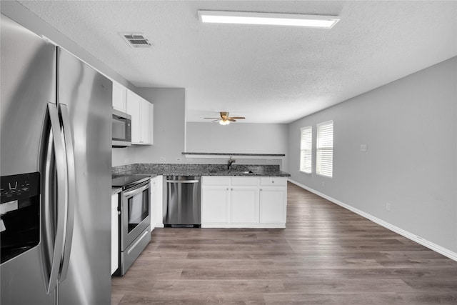 kitchen featuring white cabinets, sink, ceiling fan, a textured ceiling, and stainless steel appliances