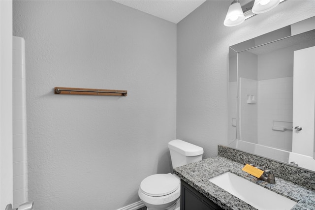 bathroom with a shower, vanity, and toilet