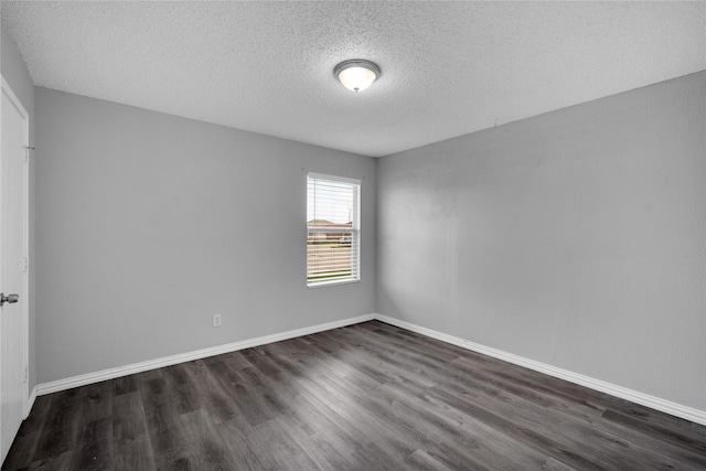 empty room with dark hardwood / wood-style flooring and a textured ceiling