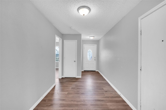 entrance foyer featuring dark wood-type flooring and a textured ceiling