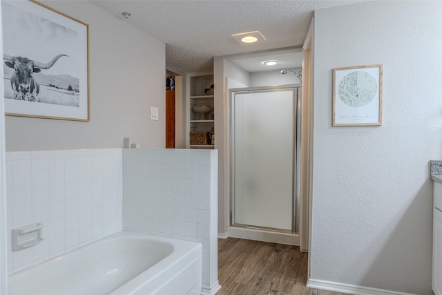 bathroom with separate shower and tub, vanity, a textured ceiling, and hardwood / wood-style flooring