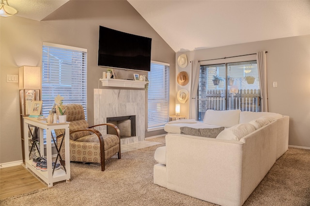 carpeted living room with lofted ceiling and a tiled fireplace