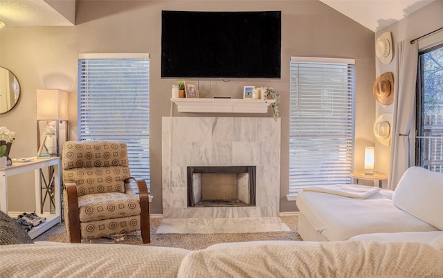 living room featuring a fireplace, carpet, and vaulted ceiling